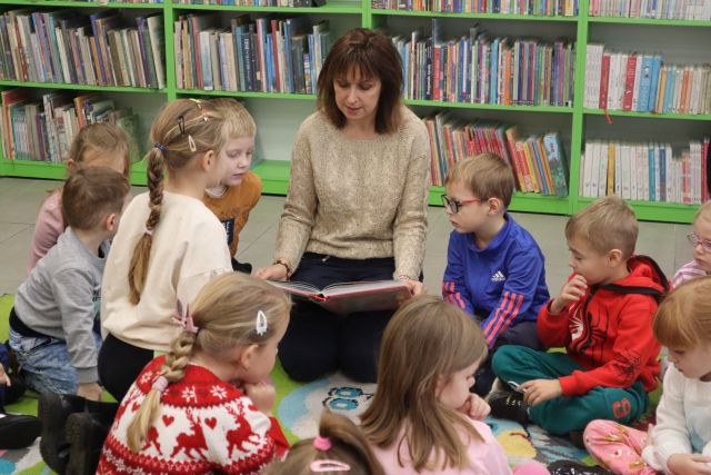 dyrektorka biblioteki czyta dzieciom książkę