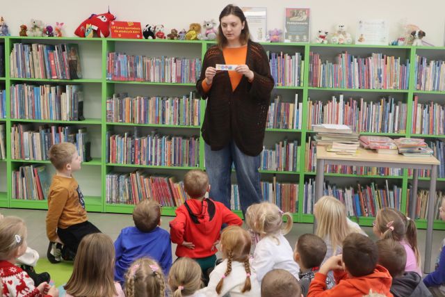 bibliotekarka pokazuje przedszkolakom rebus
