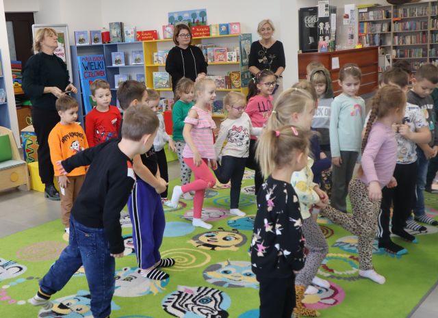 przedszkolaki stoją na jednej nodze