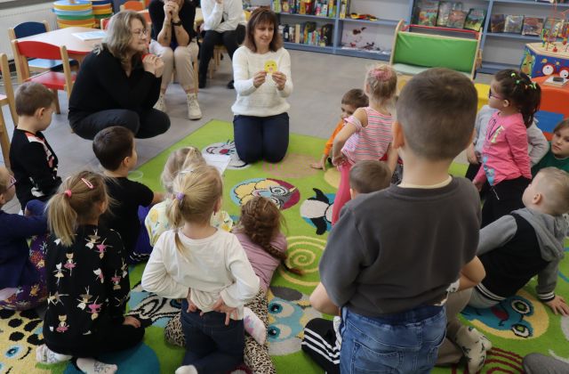bibliotekarki pokazują dzieciom uśmiechnięte buźki