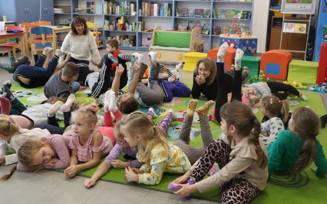 przedszkolaki leżą na kolorowym dywanie