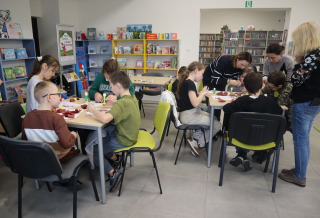 dzieci siedzą przy stołach