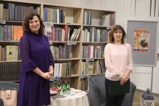 na zdjęciu stoją dwie kobiety, w tle regały z książkami