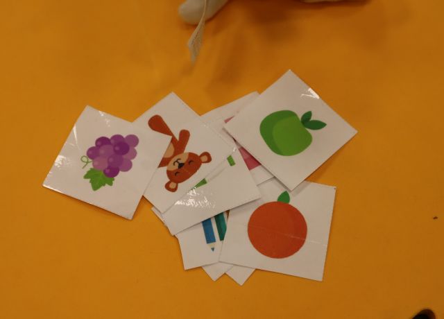 na pomarańczowych planszach kartki z ilustracjami owoców