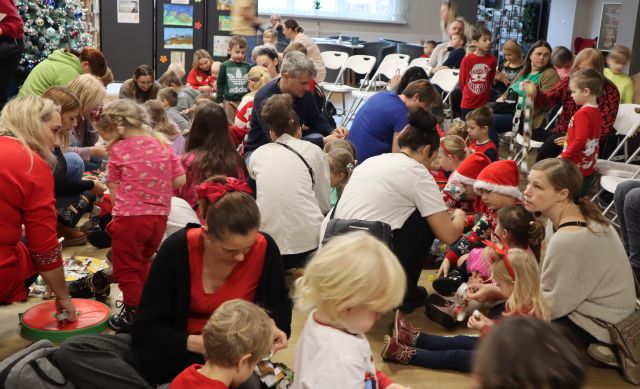 dzieci z rodzicami robią łańcuch na choinkę