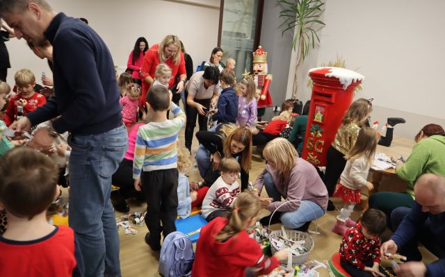 dzieci z rodzicami robią łańcuch na choinkę