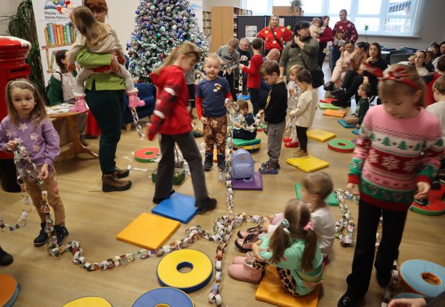 dzieci z rodzicami robią łańcuch na choinkę