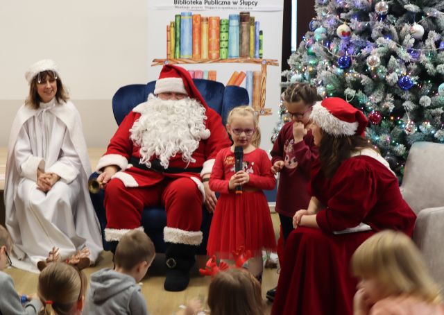 dwie dziwczynki śpiewają stojąc przed Panią Zimą, Mikołajem i Mikołajową