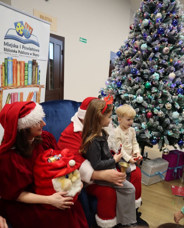 dzieci pozują do zdjęcia z mikołajem i mikołajową