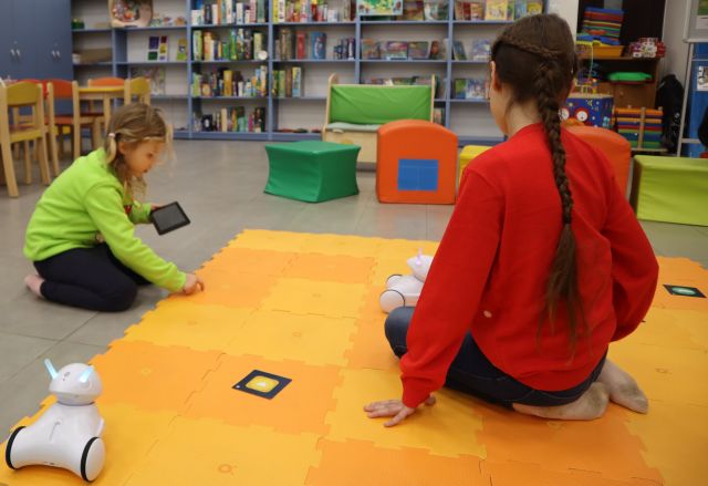 dwie dziewczynki sterują robotami Photon używając tabletów