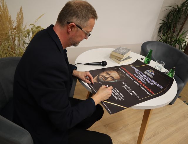 autor podpisuje się na plakacie