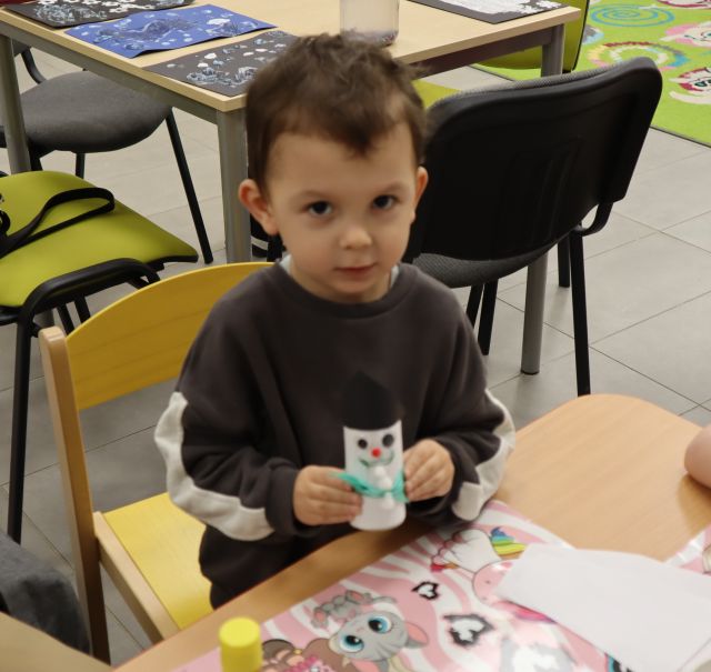 chłopiec pokazuje wykonanego przez siebie bałwana z rolki po papierze toaletowym