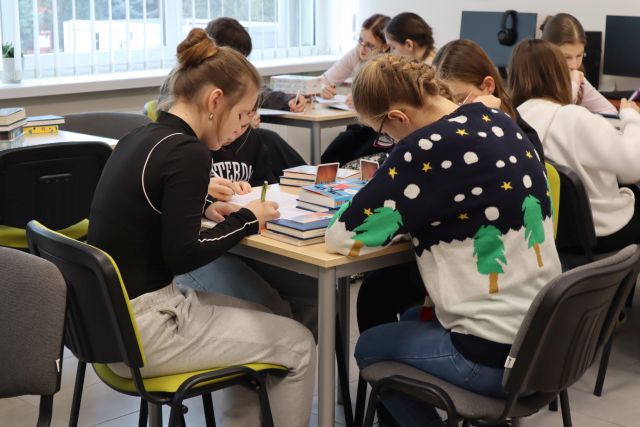młodzież pisze na kartkach siedząc przy stoliku