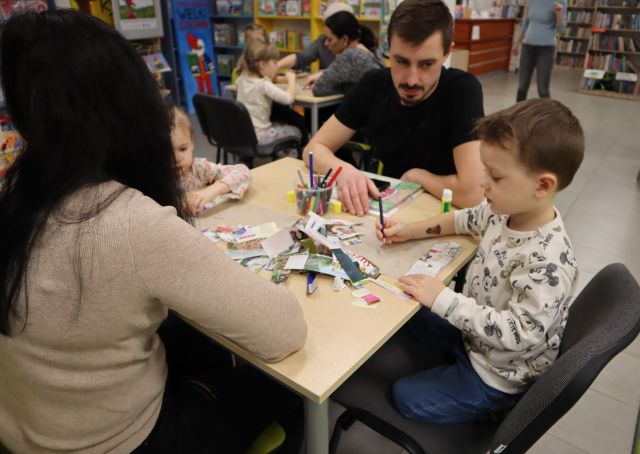 dzieci z rodzicami malują na kartkach