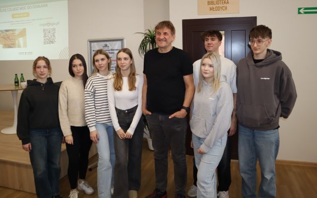 6 młodzieży pozuje do zdjęcia z podróżnikiem