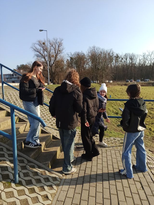 młodzież stoi na schodach i trawie