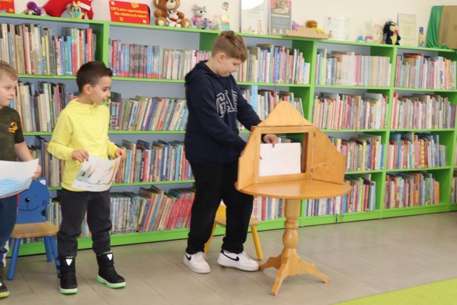 chłopiec prezentuje swoje plansze narysowane do teatrzyku kamishibai