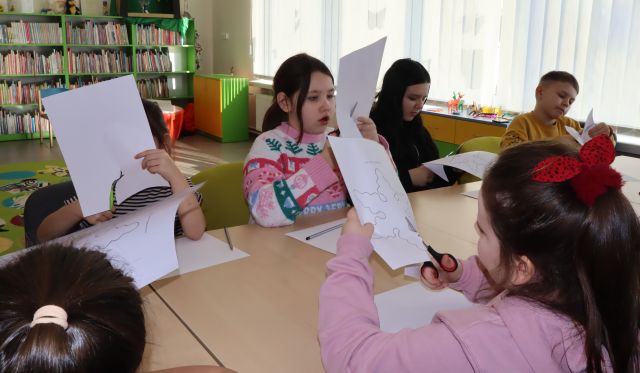 dzieci wycinaja nożyczkami rysunki narysowane na kartkach