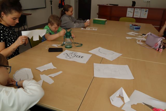 dzieci długopisami 3D drukują na kartkach