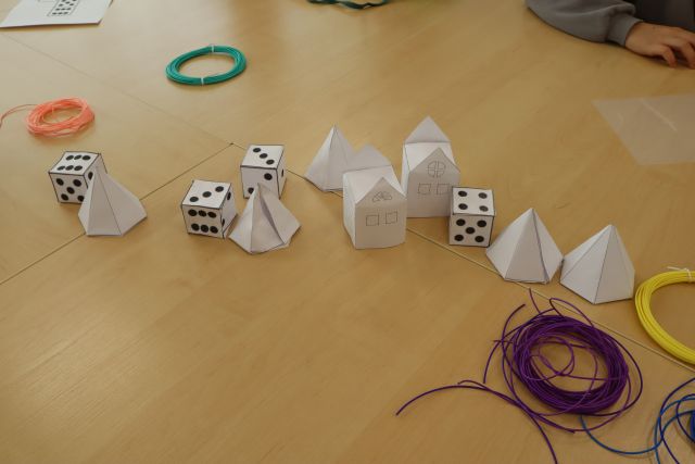 na stole kostki z papieru i figury geometryczne