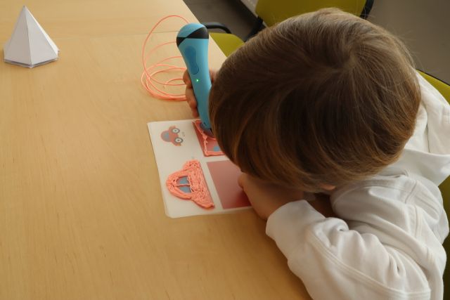 chłopiec długopisem 3D drukuje samochód
