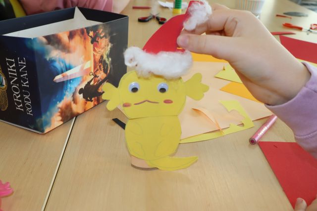 żółta figurka z papieru w czerwonej czapce
