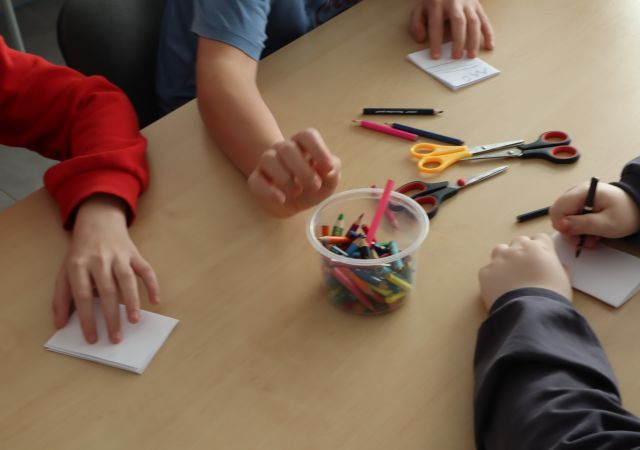 dłonie rysujące na małych kartkach