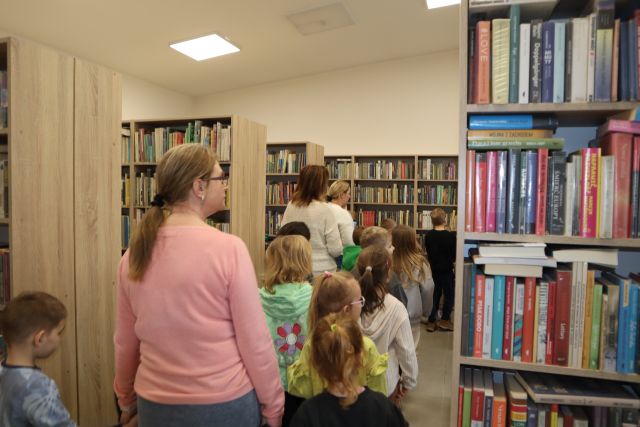 przedszkoalki w sali z regałami z książkami