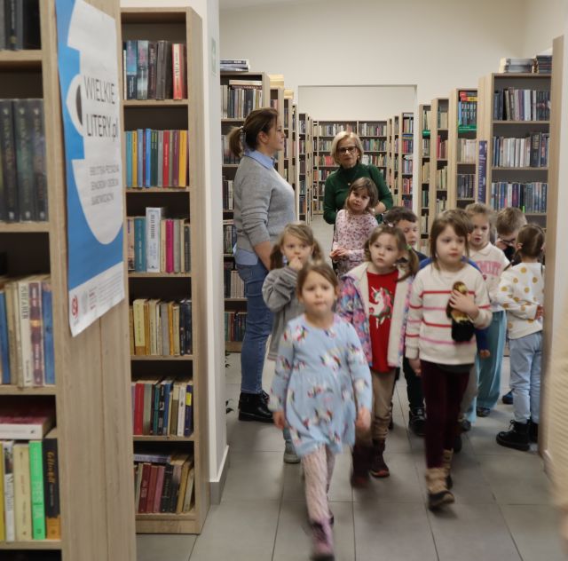 na zdjęciu regały z książkami i dzieci