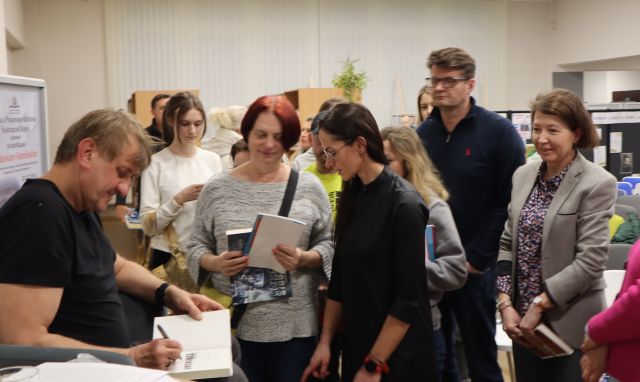 uczestnicy spotkania czekają na autograf od podróżnika