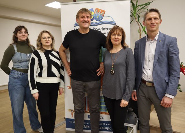 3 bibliotekarki i burmistrz pozują do zdjęcia z podróżnikiem