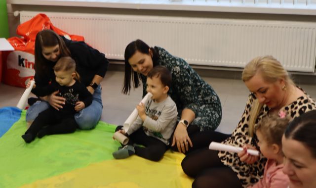 dzieci dmuchają w zwinięte w rulon kartki