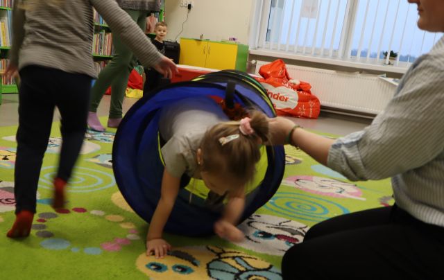 dzieci przechodzą przez materiałowy tunel