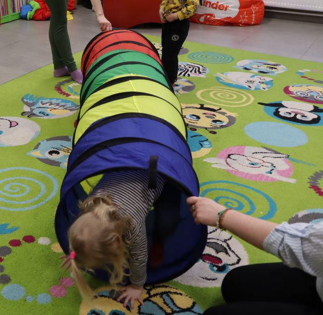 dzieci przechodzą przez materiałowy tunel