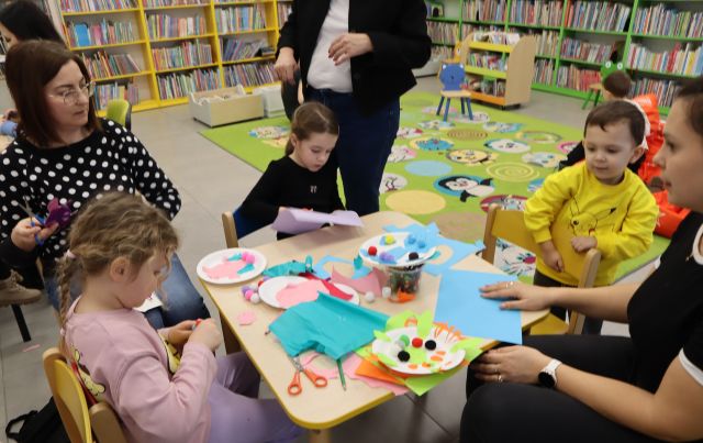 dzieci z rodzicami wycinają dinozaury