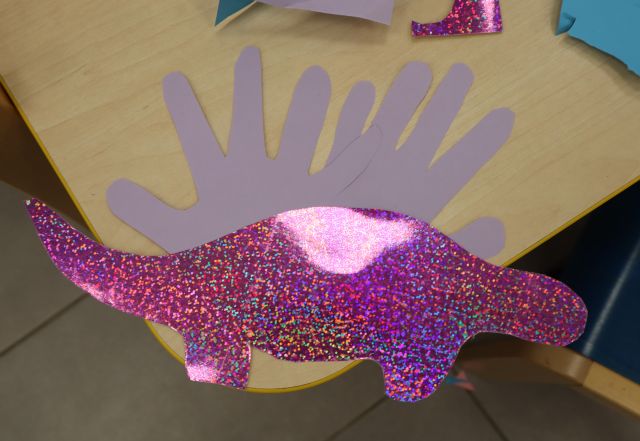 na stole leży fioletowy dinozaur z papieru