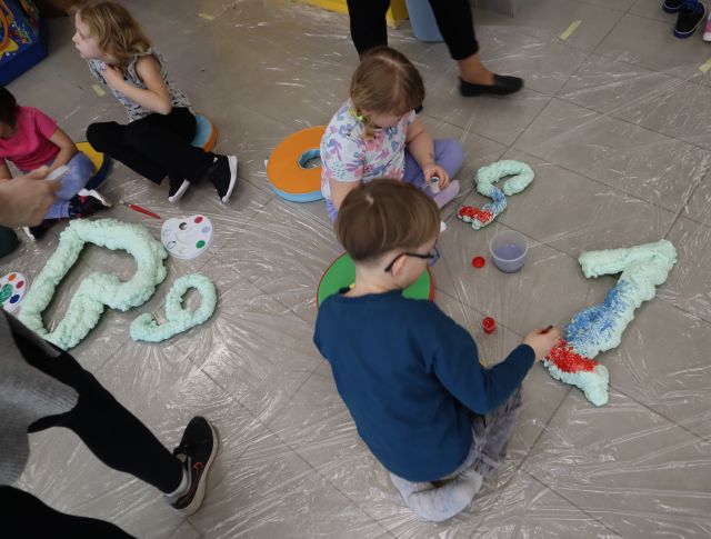 dzieci malują farbkami figury z pianki montażowej