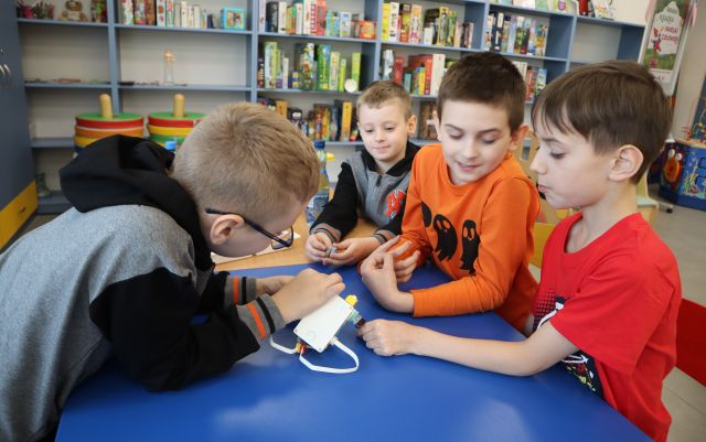 4 chłopców buduje robota z klocków Lego