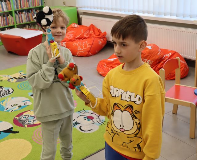 dwóch chłopców prezentuje swoje budowle z klocków LEGO