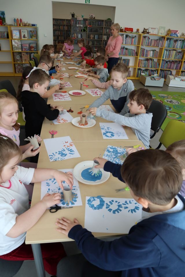 przedszkolaki przy stolikach malują