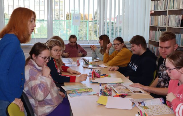 przy stołach siedzi młodzież, na stołach gazety