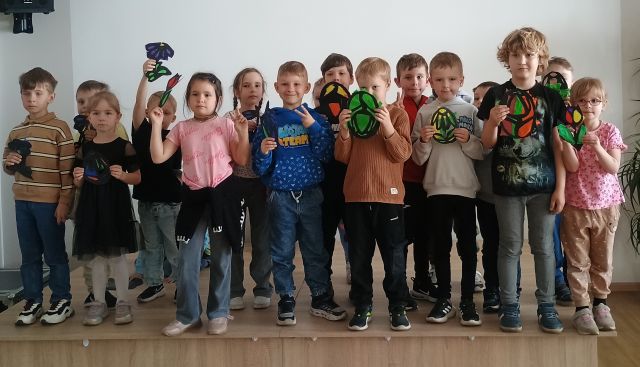 przedszkoalki pozują do zdjęcia z własnoręcznie zrobionymi witrażami