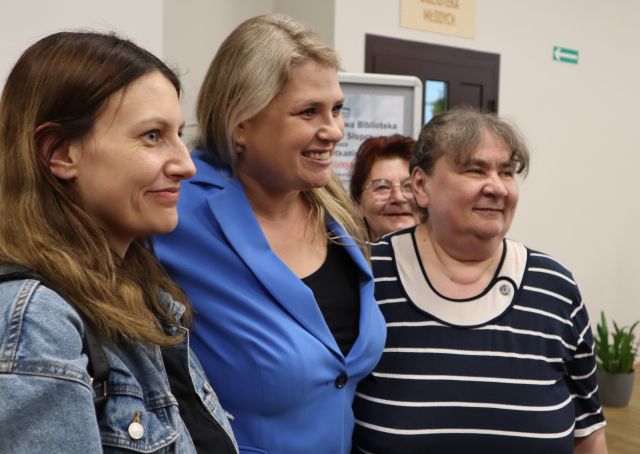 Romanowska obejmuje dwie kobiety, z tyłu stoi kobieta
