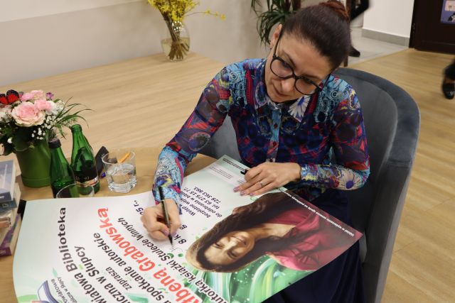 autorka podpisuje się na plakacie