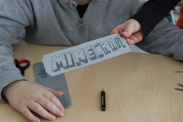 dłoń trzymająca zakładkę z napisem minecraft