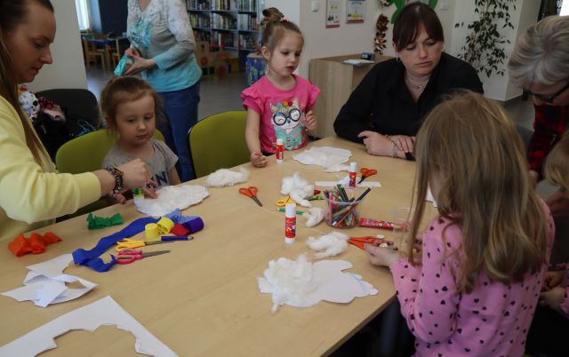 dzieci przy stołach wykonują prace plastyczne