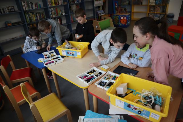 6 uczestników warsztatów pochylonych nad klockami