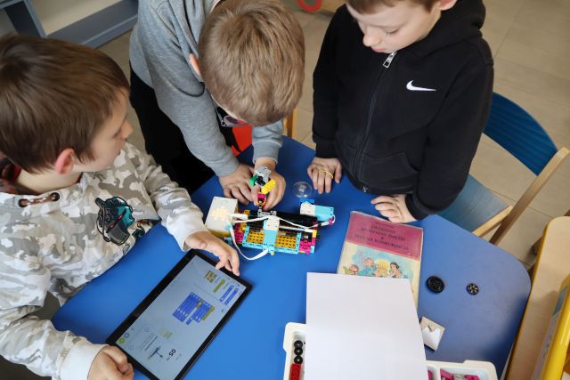 trzech chłopców buduje z klocków LEGO