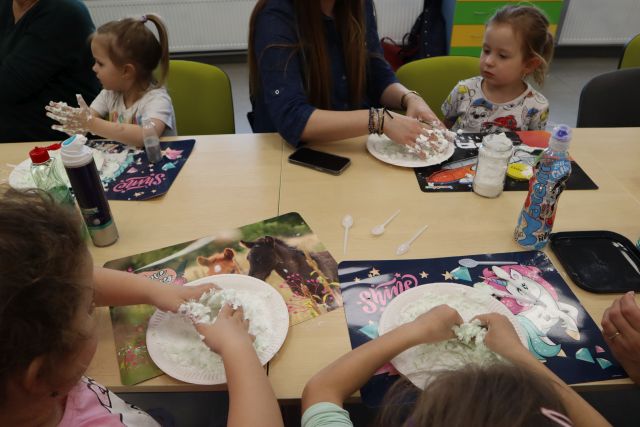 dzieci mieszają masy na talerzykach