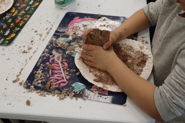 dziecięce dłonie mieszają masę z mąki i barwników